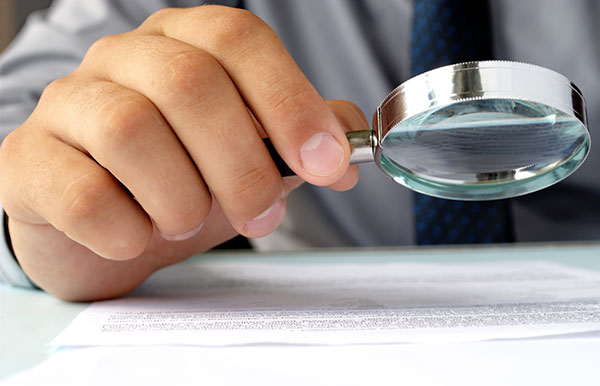 inspecting document with magnifying glass